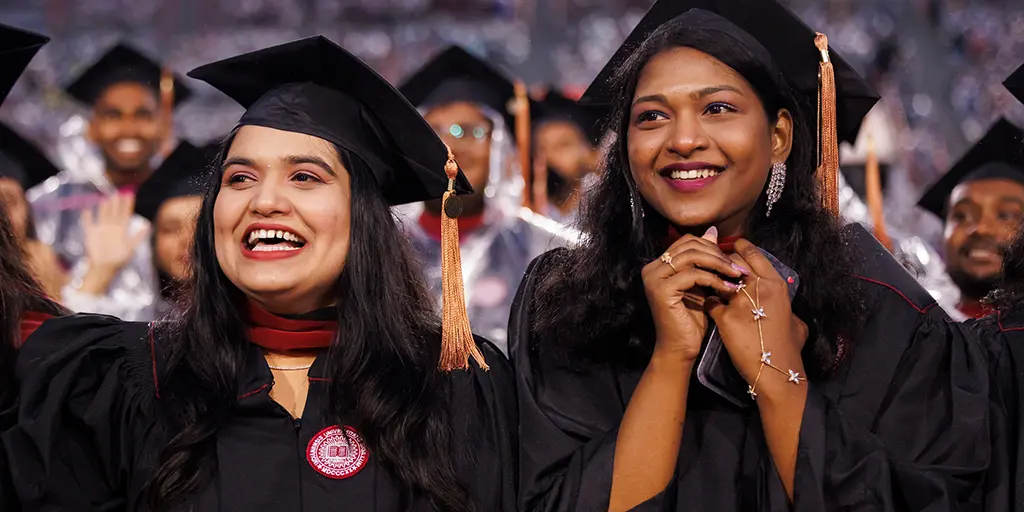 Graduates react during the conferral of degrees during IUPUI Commencement.